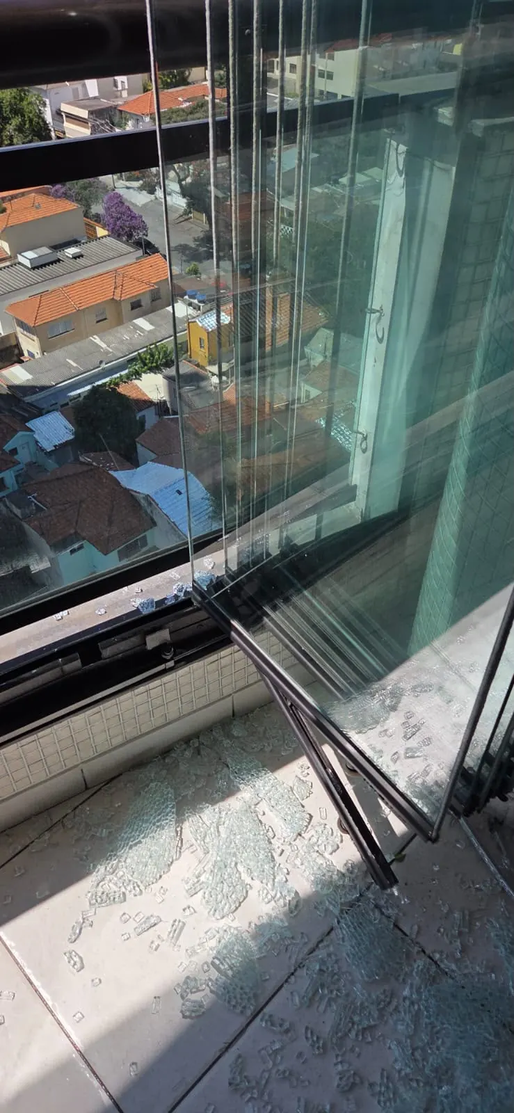 Detalhe de trilho e folhas de vidro da sacada